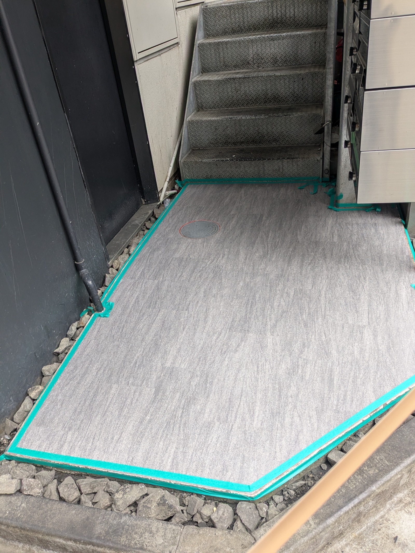 シート貼りで滑りにくく仕上げたテナントビル裏口の土間